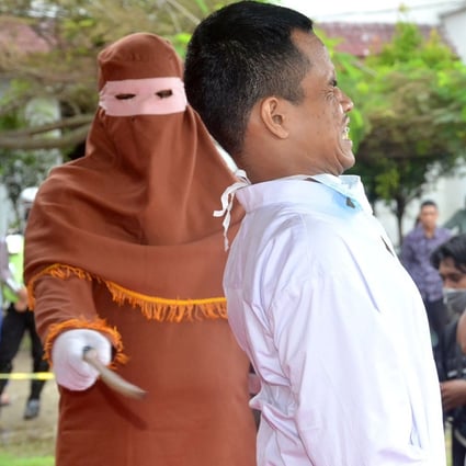 A man is publicly flogged by a member of the sharia police on November 26, 2020. Photo: AFP