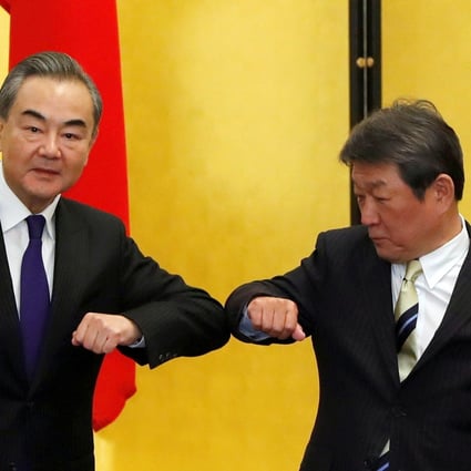 China’s Foreign Minister Wang Yi (left) and his Japanese counterpart Toshimitsu Motegi bump elbows during their meeting in Tokyo. Photo: Reuters