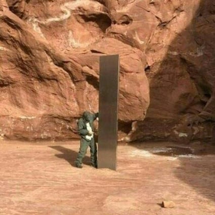 A worker inspects a metal monolith that was found installed in the ground in a remote area of red rock in Utah on November 18. Photo: Utah Department of Public Safety handout via AP