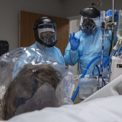 Medical staffers check on the comfort of a patient wearing a helmet-based ventilator in Houston, Texas. Photo: AFP