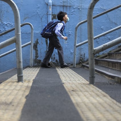 A boy makes his way to school on November 30 in Wan Chai. All schools will suspend face-to-face classes from Wednesday as the fourth wave of Covid-19 pandemic continues to worsen in Hong Kong. Photo: Nora Tam