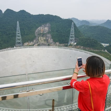 A woman takes photos of the Five-hundred-metre Aperture Spherical Telescope, also known as FAST. The world’s largest full dish radio telescope is located in Pingtang County, in southwest China’s Guizhou province. Photo: Xinhua