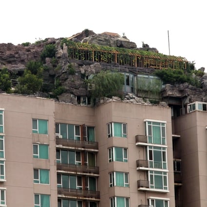 A 26-storey residential building in Beijing in 2013 on top of which the owner built a villa with a fake mountain and trees. Illegal structures are common throughout China and Hong Kong. Photo: Simon Song