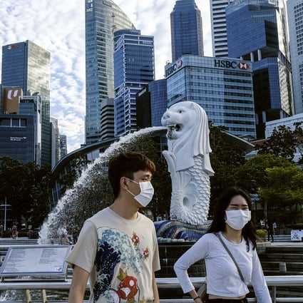A couple wearing face masks pass the Merlion statue in Singapore. Photo: AP
