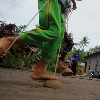 Traditional games and toys are having a revival in Indonesia. Egrang batok (above) uses coconut shells as mini stilts. Photo: Nugroho Hadi Santoso/NurPhoto via Getty Images
