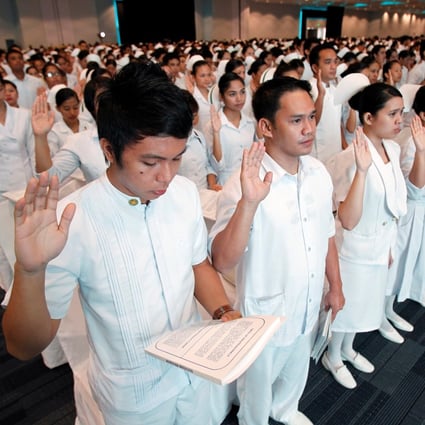 Newly graduated nurses take their oaths at a ceremony in a mall in Manila in 2010. Photo: Reuters