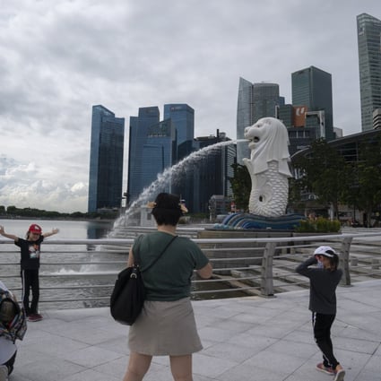 People take photos at the Merlion Park in Singapore. Photo: EPA