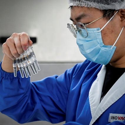 A Sinovac employee checks Covid-19 vaccines during a media tour in September of a new factory built in Beijing to produce the vaccines. Hong Kong has announced procurement agreements with three pharmaceutical companies, including Sinovac. Photo: AFP