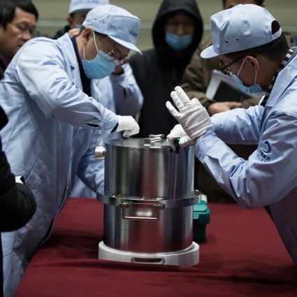 Scientific researchers transfer a container loaded with moon samples retrieved by the Chang’e-5 probe. Photo: Xinhua