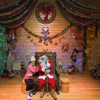 A visitor poses with Santa, played by Ville Haapassallo from Finland, near Mohe in China. Photo: Reuters
