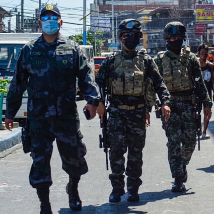 Policemen patrol a market in Manila. A bizarre prank has highlighted public anger and mistrust of the force. Photo: AFP