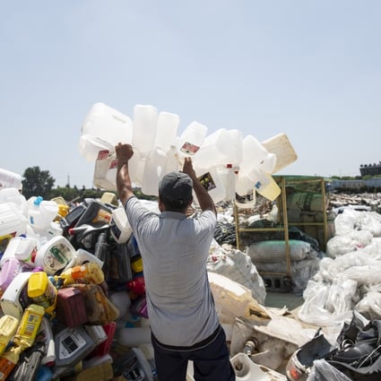 A man adds plastic containers to a heap of discarded plastic in Shanghai. China generates more than 80 million tonnes of plastic waste a year, and has vowed to reduce the total next year. Cities have begun implementing curbs on plastic usage, such as a ban on plastic straws in Chengdu. Photo: AFP