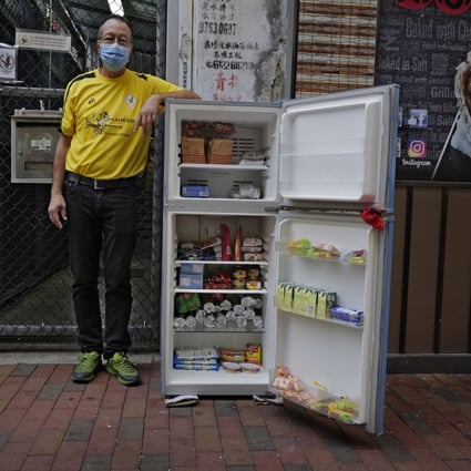 Ahmed Khan with the community refrigerator that offers free food and other items to those who need it on Woosung Street in Hong Kong’s Jordan neighbourhood. Photo: AP