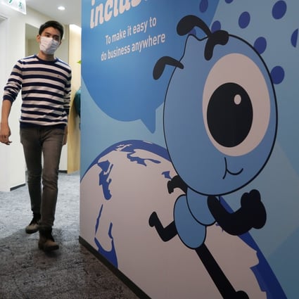 An employee walks past a graphic of Ant Group's mascot at the company’s office in Hong Kong. Photo: AP