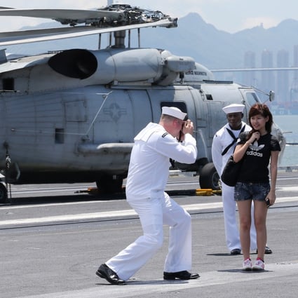 A sailor photographs a visitor on the deck of the USS George Washington during a 2012 stop in Hong Kong. Photo: Felix Wong