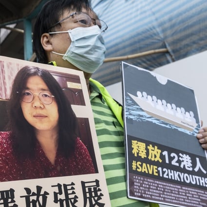 A pro-democracy activist holds up signs in support of Zhang Zhan and the 12 detainees arrested at sea outside Beijing’s liaison office in Hong Kong on Monday. Photo: EPA-EFE