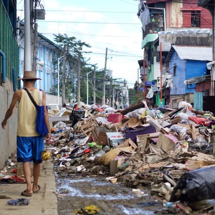 Rubbish is piled up in the middle of the street after floods in Barangay Malanday, Marikina City, the Philippines. An average of 20 typhoons a year now hit the country, with flooding devastating many towns and cities. Photo: AJ Bolando