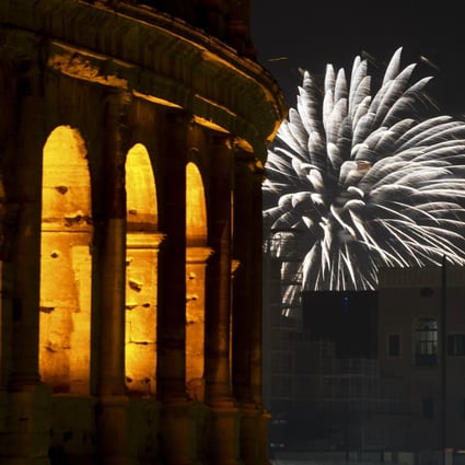Fireworks explode in the sky next to Rome’s Colosseum on New Year’s Eve. Photo: AP
