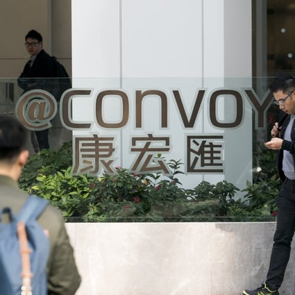 Pedestrians walk past the "@Convoy" building, which houses the headquarters of Convoy Global Holdings Ltd., in Hong Kong on Monday, December 11, 2017. Photo: Bloomberg