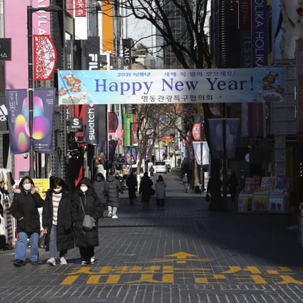 People wearing face masks walk along a shopping street in Seoul on Saturday. South Korea’s population shrank last year for the first time in its history. Photo: AP