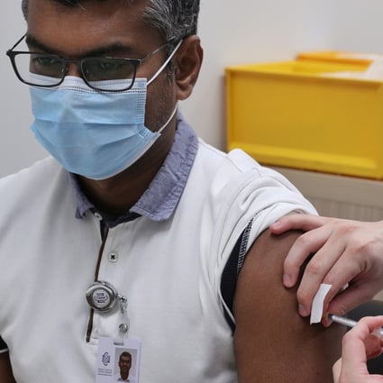 A health care worker receives a dose of the coronavirus vaccine at the National Centre for Infectious Diseases in Singapore. Photo: Reuters