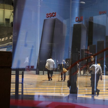 Reflection of pedestrians on an electronic board showing the Hang Seng Index in Central. Hong Kong and China stocks advanced on first day of 2021. Photo: May Tse