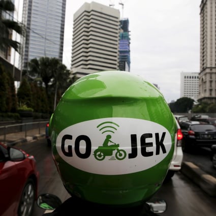 A Gojek driver rides his motorcycle through a business district street in Jakarta, Indonesia on June 9, 2015. Photo: Reuters