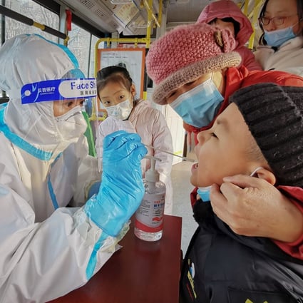 A child gets tested in Dalian, northeast China, in December. A WHO team has not yet been granted entry to the country to investigate the origins of Covid-19. Photo: AFP