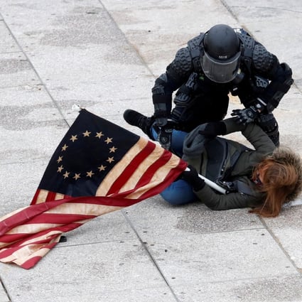 A police officer detains a pro-Trump protester as crowds storm the US Capitol. Photo: Reuters