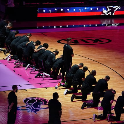 Miami Heat forward Meyers Leonard stands while teammates kneel during the playing of the national anthem prior to the game against the Boston Celtics. Photo: USA Today