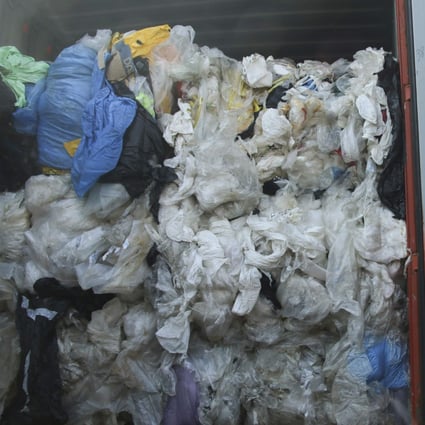 An officer stands next to a container full of illegal imported plastic waste in Batam, Indonesia, in July 2019, when the country returned seven shipping containers of such waste to France and Hong Kong. Southeast Asia has been a hotbed of illicit plastic waste trade since China enacted a ban on “foreign waste”. Photo: AFP