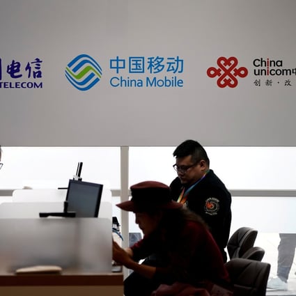 Signs of China Telecom, China Mobile and China Unicom are seen during the 2018 China International Import Expo in Shanghai. Hong Kong and Asian markets follow gains in US equities as Trump concedes defeat in US election but major Chinese telecoms stocks falter on NYSE and index removal blows. Photo: AFP