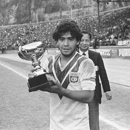 Argentina's soccer superstar Diego Maradona, clad in a jersey of Hong Kong side Seiko, holds the trophy after his Boca Juniors team won 2-0 at Hong Kong Stadium on January 10, 1982. Photo: Martin Chan