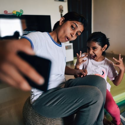 A mother and daughter take a selfie at home. Many parents enjoying posting such images on social media, but what are the implications for the child? Photo: Getty Images