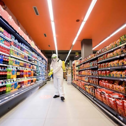 A worker disinfects the floor of a supermarket as a preventive measure against the spread of coronavirus. So much of the infrastructure of our civilisation is maintained by low-paid workers. Photo: AFP