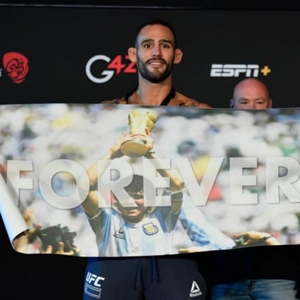 UFC welterweight fighters Santiago Ponzinibbio and Li Jingliang hold up a banner of Argentinian footballer Diego Maradona at their face-off. Photo: Twitter/Santiago Ponzinibbio