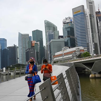 Women walk across a bridge on Marina Bay in Singapore. Photo: AFP