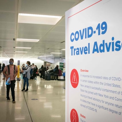 Travellers wait for their luggage next to a Covid-19 travel advisory at Newark International Airport in Newark, New Jersey. File photo: AFP