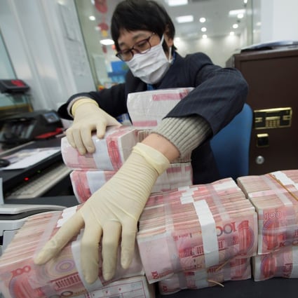 A staff member wearing a face mask arranges stacks of Chinese yuan banknotes at a bank in Nantong, Jiangsu province, China January 30, 2020. Picture taken January 30, 2020. China Daily via REUTERS ATTENTION EDITORS - THIS IMAGE WAS PROVIDED BY A THIRD PARTY. CHINA OUT.