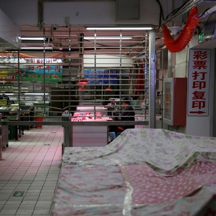 A man sits at a meat-market stall in a partially closed shopping centre in Beijing amid the coronavirus outbreak last year. Photo: Reuters