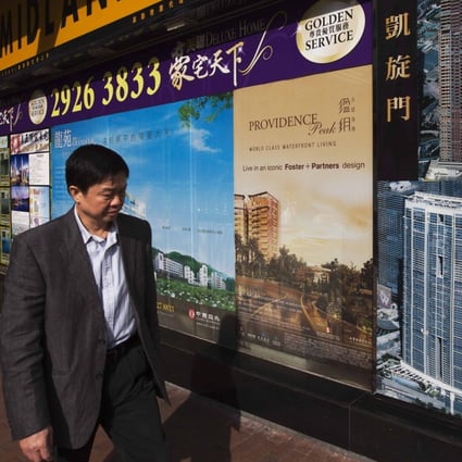 A man walks past a real estate agency displaying advertisements of residential developments near West Kowloon. Prospective buyers should exercise care when assessing promotional messages. Photo: Reuters