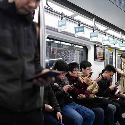 Commuters use their phones on a subway in Beijing on April 8, 2019. Photo: AFP