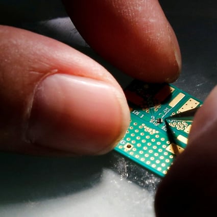 A researcher plants a semiconductor on an interface board during research work. Photo: Reuters