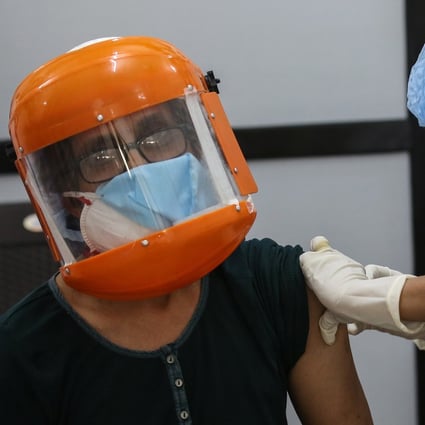 A woman wearing a face mask and shield receives her first shot of a coronavirus vaccine in India, despite widespread distrust in the country about the inoculation drive. Photo: EPA-EFE