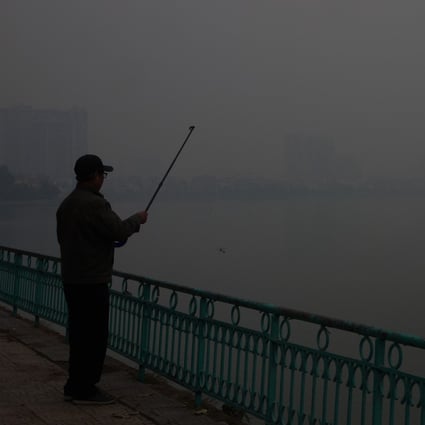 A man fishes at West Lake as dense smog descends on Hanoi in January 2021. The Vietnamese capital’s air quality has been ranked among the worst in the world. Photo: Sen Nguyen