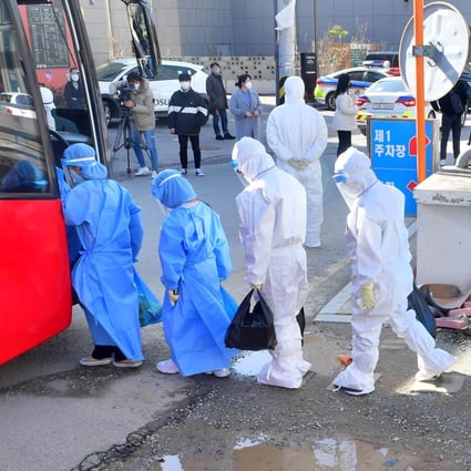 Children in protective clothes who have tested positive for Covid-19 at TCS International School in Gwangju are led onto a bus to travel to medical facilities for treatment. Photo: kjdaily.com for SCMP