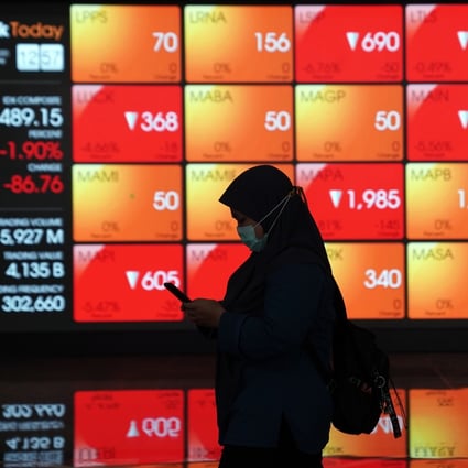 A woman walks past an electronic board displaying stock prices in the lobby of the Indonesia Stock Exchange in Jakarta. Photo: Bloomberg