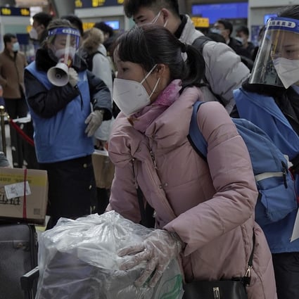 Staff wearing face masks and shields direct rail passengers in Beijing on Thursday, although the number travelling was said to be smaller than in previous years. Photo: AP