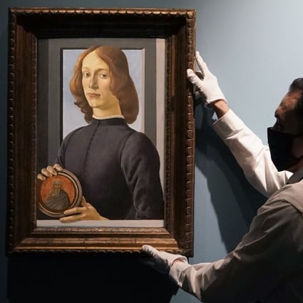 An art handler at Sotheby’s hangs Botticelli’s Young Man Holding a Roundel, which sold in New York for US$92.2 million, smashing the previous auction record for a work by the Italian Renaissance artist. It is considered one of Botticelli’s finest portraits. Photo: AFP