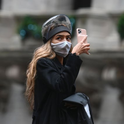 A woman takes a picture outside the New York Stock Exchange on November 30. Photo: AFP